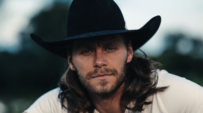 Warren Zeiders wearing a white tshirt and black cowboy hat\